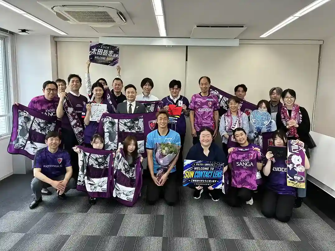 京都サンガF.C.太田岳志選手とサンコンタクトレンズ社員の集合写真