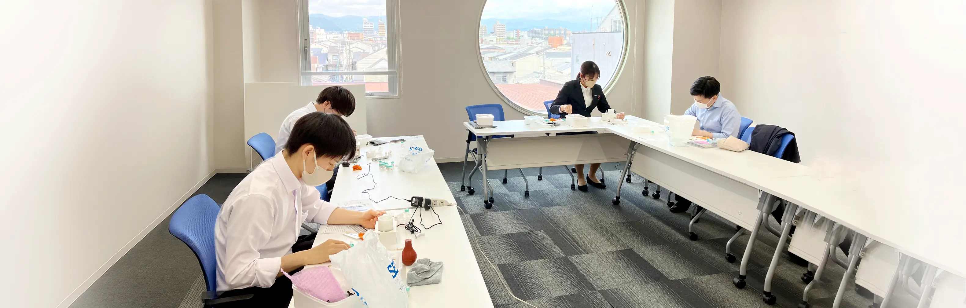 レンズの検査機器を使って研修を受ける営業スタッフ