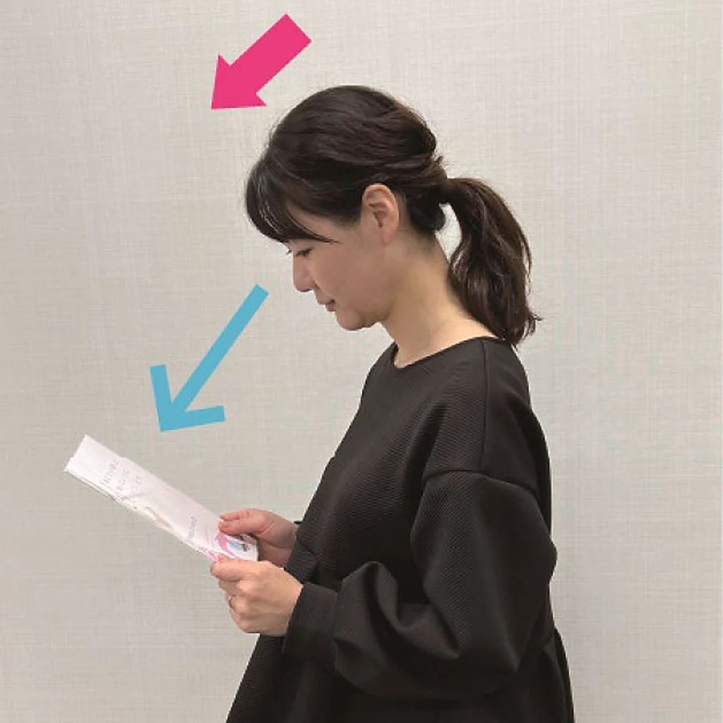 よくない例：顔ごと下を向いて手元の書類を見ている女性